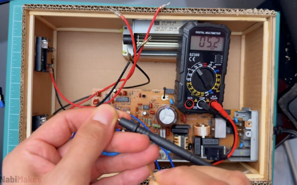 Digital multimeter reading 5.2 V while testing the 5 V output of the printer power supply inside the case