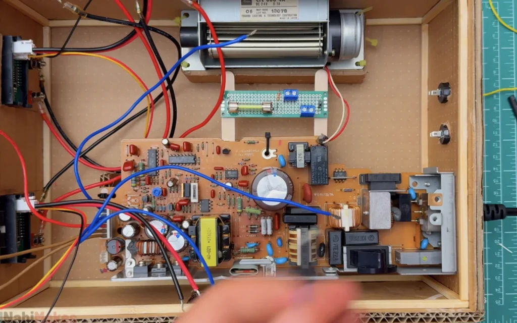 Wiring inside the power supply case: meters, binding posts, the fan and a perfboard with a glass fuse holder and screw terminals