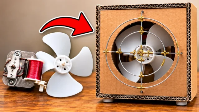 A salvaged microwave fan motor and white blade beside the finished DIY desk fan: a cardboard box with a round stainless steel wire fan guard wrapped in gold aluminium wire
