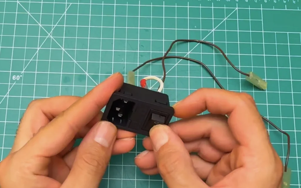 Power inlet module with fuse holder and rocker switch, with two brown wires ending in insulated spade connectors and a white jumper wire