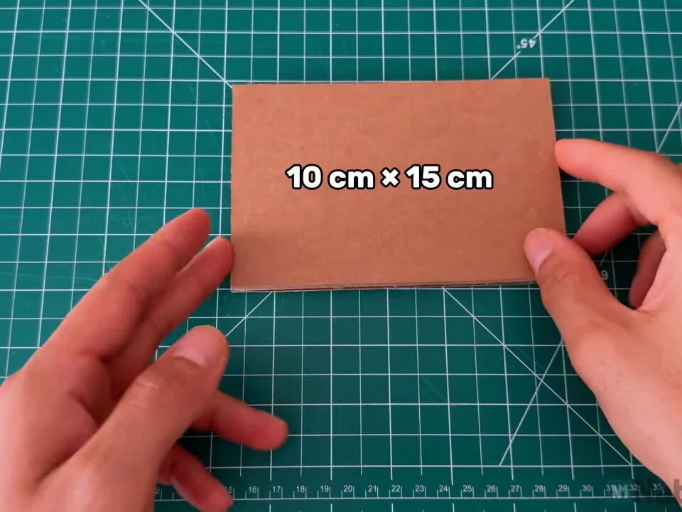 Rectangle of corrugated cardboard labelled 10 cm × 15 cm on a green cutting mat