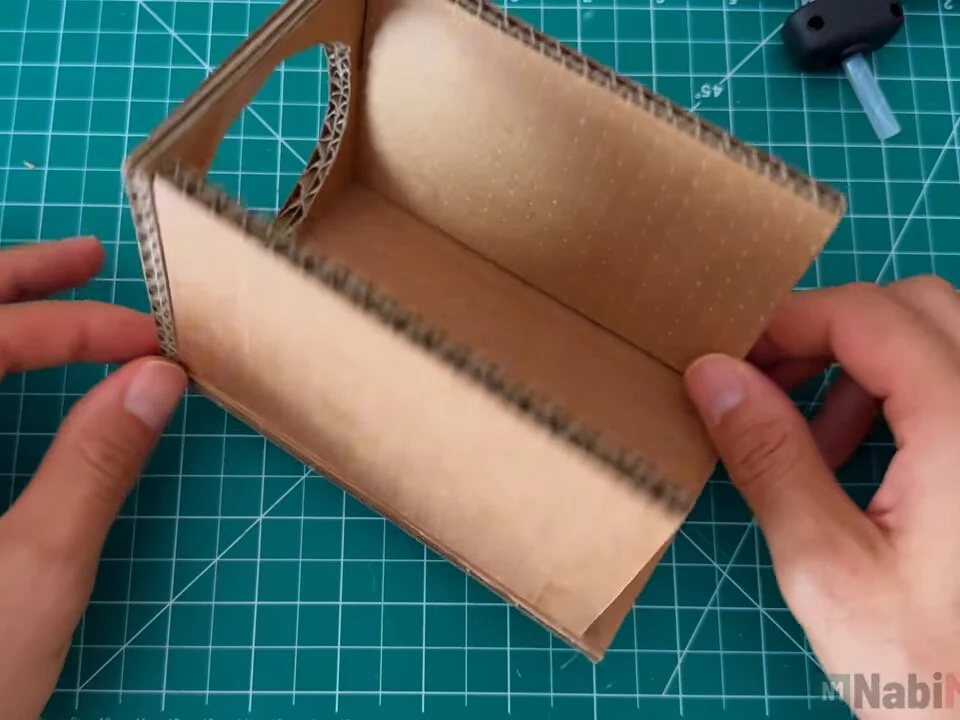 Open cardboard box made of front panel, base and two sides