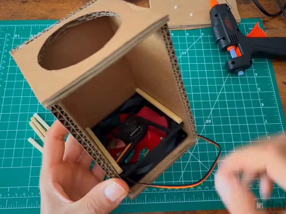 Box standing upright with the first fan glued in behind the front opening
