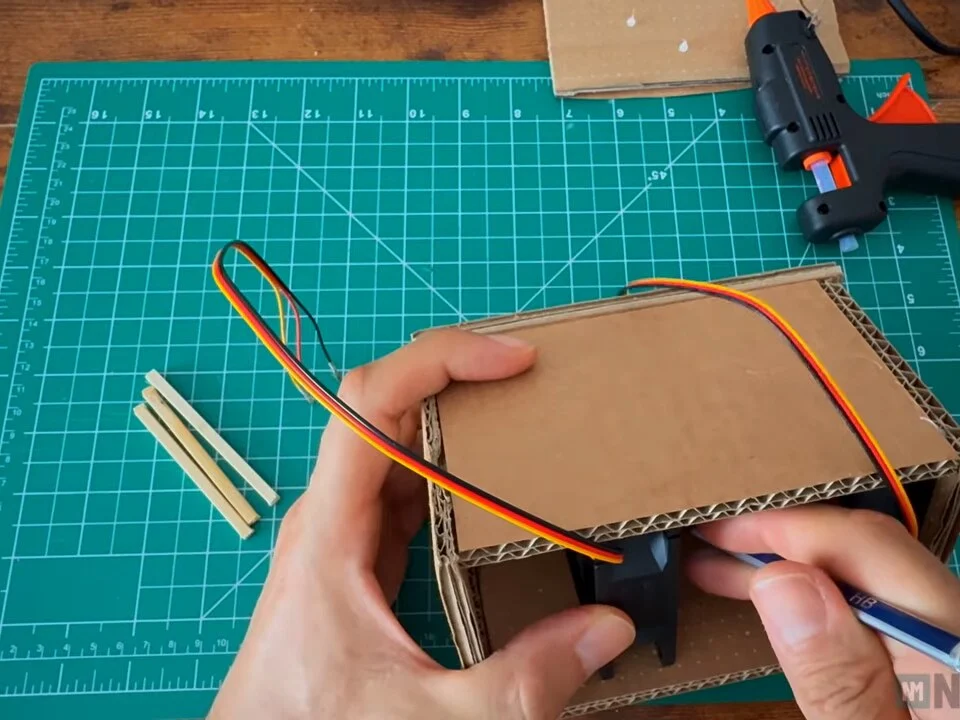 Marking the position of the second fan inside the box with a pen