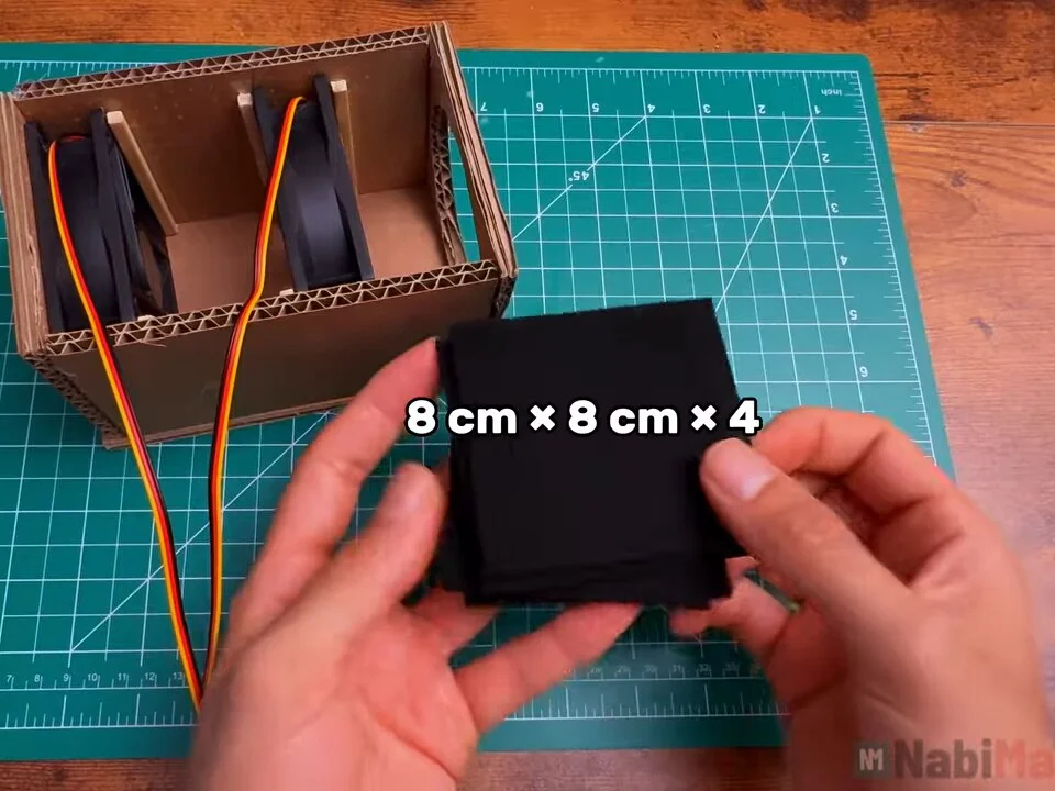 Four black carbon filter squares, 8 cm × 8 cm, held next to the box
