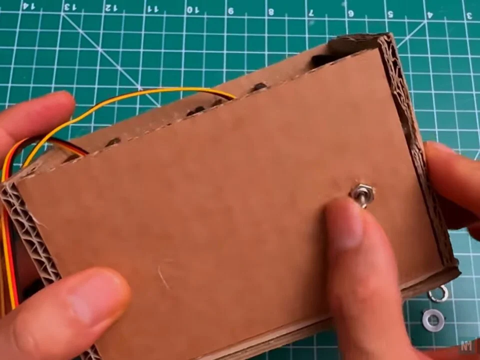 Mini toggle switch fixed through the cardboard side panel with its nut