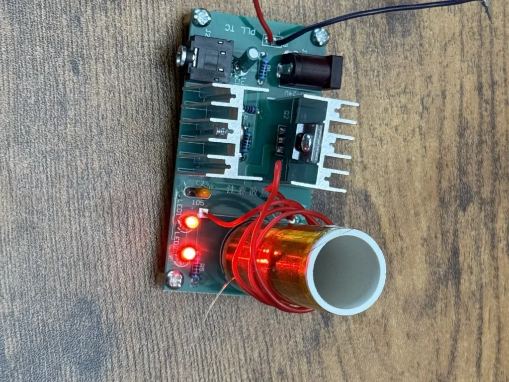 Mini Tesla coil powered on from a bench supply, with both red LEDs lit and the coil ready for testing