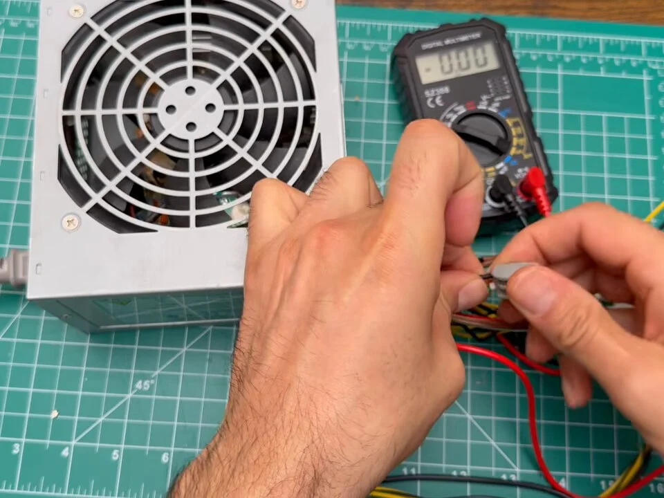 Joining the green wire to a black ground wire next to the power supply and a multimeter