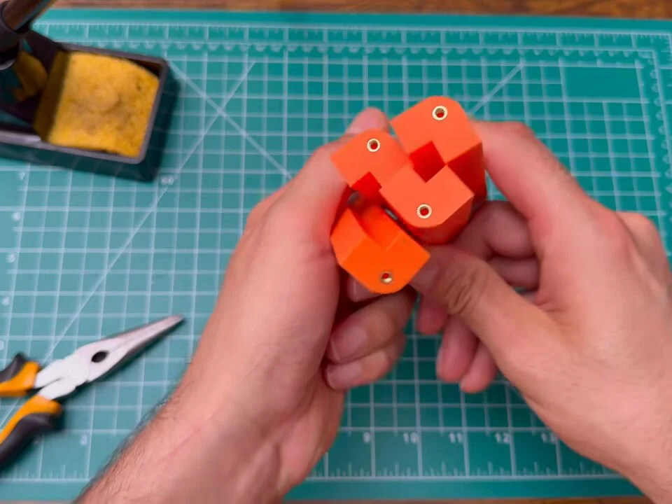 Orange printed frame corner pieces slid together in two hands