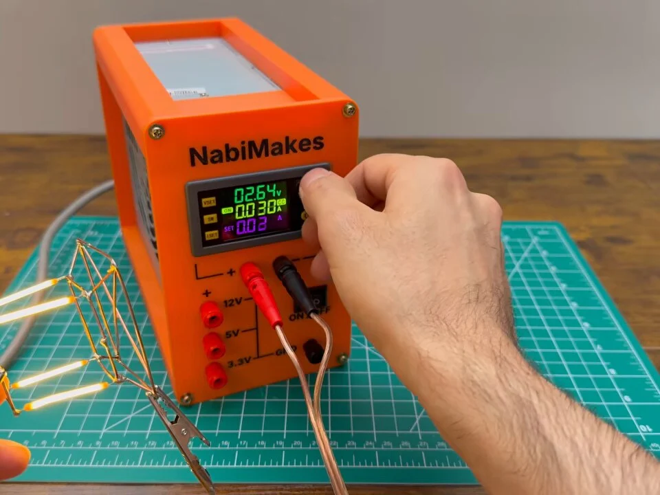 LED filament cube glowing while the current is turned up on the bench power supply